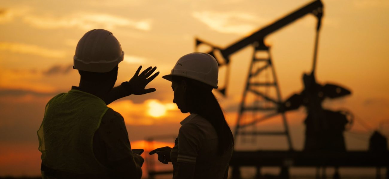 silhouette-oilfield-workers-meeting-crude-oil-pump-unit-sunset-min